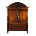 AN EMPIRE STYLE MAHOGANY ARMOIRE the arched carved pediment above a dentil frieze, a pair of