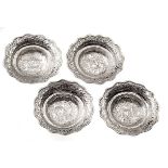 A SET OF FOUR INDIAN SILVER DISHES each hand hammered design of flowerheads and foliage 195g in