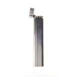 A CARTIER LIGHTER silver toned with reeded pattern, hallmarked Cartier, accompanied by a red