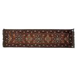 AN AFGHAN RUNNER, MODERN the madder-red field with five floral medallions and half medallion