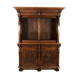 AN OAK BOOKCASE, 19TH CENTURY in two parts, the outswept pediment above two glazed panelled doors,