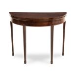 A GEORGE III MAHOGANY TEA TABLE the hinged crossbanded demi-lune top above a plain frieze, on