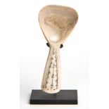 A BONE SPOON the handle carved with a geometric design 10cm long