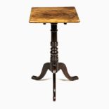 A VICTORIAN FLAME MAHOGANY OCCASIONAL TABLE the rectangular top above a turned column, on three