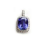 A TANZANITE AND DIAMOND PENDANT claw set to the centre with a rectangular cushion-cut tanzanite
