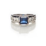 A SAPPHIRE AND DIAMOND RING centred with a claw-set carré-cut sapphire weighing approximately 1.