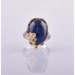 A TANZANITE AND DIAMOND RING centred with an oval cabochon tanzanite weighing 25.60cts,
