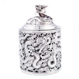 A CHINESE SILVER JAR AND COVER the pierced cylindrical body chased with dragons amongst clouds