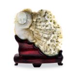 A CHINESE CARVED JADE PLAQUE OF A SLEEPING BOY the figure curled upon a shell above foaming sea, the