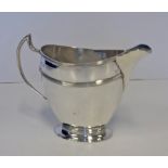 AN EDWARDIAN SILVER MILK JUG, REID & SONS, LONDON, 1909 the flared oval body with reeded bands,