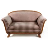 A BIEDERMEIER WALNUT SETTEE the padded back beneath a curved top rail, curved padded arms, stuff-