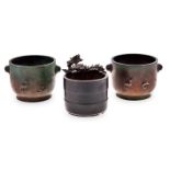 A PAIR OF SMALL CHINESE PATINATED BRONZE TWO-HANDLED JARDINIERES each moulded in low relief with a