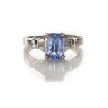 A TANZANITE AND DIAMOND RING claw set to the centre with a rectangular cushion-cut tanzanite