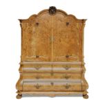 A DUTCH WALNUT ARMOIRE in two parts, the gabled pediment centred by a foliate-carved keyblock