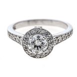 A DIAMOND CLUSTER RING centred with a round brilliant-cut diamond weighing 0.71cts, the conforming