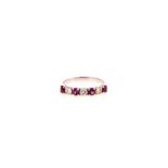 A RUBY AND DIAMOND HALF-ETERNITY RING claw-set to the centre with four circular mixed-cut rubies