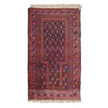 A BELOUCH PRAYER RUG, EAST PERSIA, CIRCA 1950 the madder mehrab with stylised flower-heads