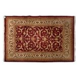 AN INDO-PERSIAN CARPET, MODERN the madder-red field with an overall design of scrolling vines and