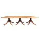 A REGENCY STYLE FLAME MAHOGANY EXTENDING DINING TABLE each D–end above a plain frieze, on a turned