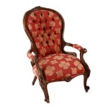 A VICTORIAN WALNUT GRANDFATHER CHAIR the curved button-back within a conforming frame centred by a
