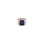 A TANZANITE AND DIAMOND RING the broad tapered band claw-set to the centre with a cushion-cut