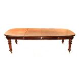 A VICTORIAN MAHOGANY EXTENDING DINING TABLE each D- end above a plain frieze, on turned fluted legs,