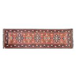 AN AFGHAN RUNNER, MODERN the madder-red field with five floral medallions depicted in blue, ivory,