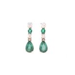 A PAIR OF EMERALD AND DIAMOND PENDENT EARRINGS each designed as an articulated line of round