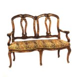 A WALNUT SETTEE, 19TH CENTURY the double arched top-rail above carved spats, padded stuff-over