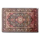 A KESHAN SILK RUG, PERSIA, MODERN the deep indigo-blue field with a rose floral medallion and