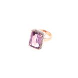 AN AMETHYST AND DIAMOND RING claw-set with a rectangular step-cut amethyst weighing approximately