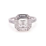 A DIAMOND RING of Art Deco style, centred with a square emerald-cut diamond weighing 1.71cts, the