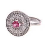 A PINK SAPPHIRE AND DIAMOND RING centred with a circular pink sapphire weighing 0.40cts, within a