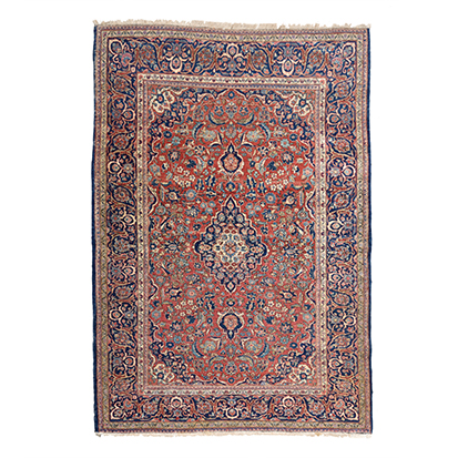 A KESHAN RUG, PERSIA, CIRCA 1960 the madder-red field with a blue and ivory floral medallion,