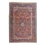 A KESHAN RUG, PERSIA, CIRCA 1960 the madder-red field with a blue and ivory floral medallion,