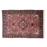 A BIRJALOU RUG, PERSIA, MODERN the red field with a black and ivory floral medallion, ivory