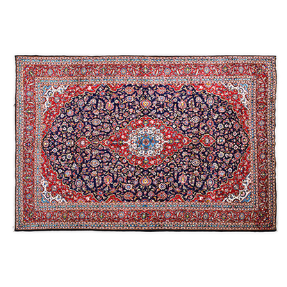 A KESHAN CARPET, PERSIA, MODERN the indigo-blue field with a red, ivory and blue floral medallion,