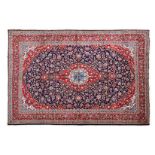 A KESHAN CARPET, PERSIA, MODERN the indigo-blue field with a red, ivory and blue floral medallion,