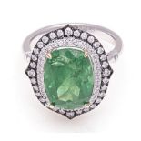 A TSAVORITE AND DIAMOND RING centred with a cushion-cut tsavorite weighing 7.739cts, within a double