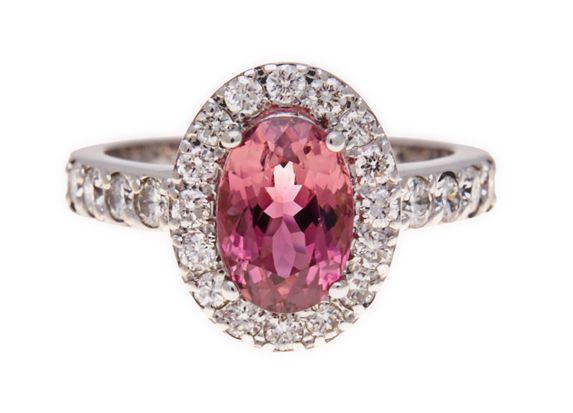 A PINK TOURMALINE AND DIAMOND RING of halo design, centred with an oval mixed-cut pink tourmaline