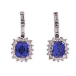 A PAIR OF TANZANITE AND DIAMOND PENDANT EARRINGS each surmount set with two baguette-cut diamonds,