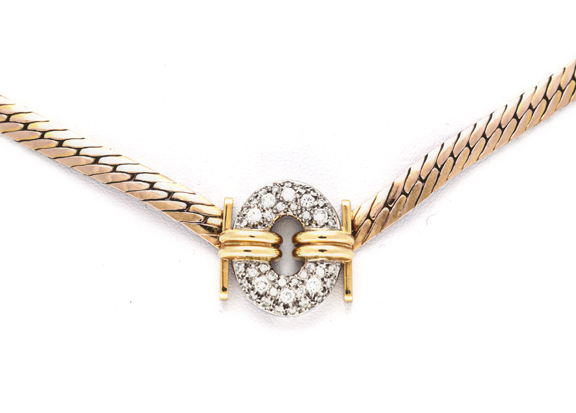 A 9CT GOLD AND DIAMOND NECKLACE composed of rose gold herringbone link chain, centred with an oval-