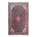 A SAROUK CARPET, PERSIA, MODERN the indigo-blue field with a red and sky-blue floral medallion,