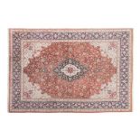 A FINE PERSIAN SILK CARPET, MODERN the madder-red field with a floral dark blue and ivory medallion,