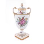 A FURSTENBERG TWO-HANDLED URN WITH COVER the tapering ovoid body, painted with floral sprays against