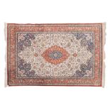 A FINE PERSIAN SILK CARPET, MODERN the ivory field with a floral terracotta and blue medallion, blue