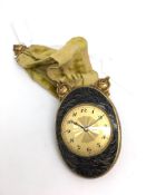 Unusual Juvenia Claudine enamel clock, black enamel oval case with scroll design, circular dial with
