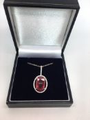 Ruby and diamond pendant, central oval cut ruby weighing an estimated 6.36cts, within a diamond