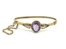 Victorian yellow metal amethyst bangle with floral motifs. Central amethyst 12x9.6mm