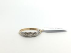 Three stone diamond ring, claw set, in yellow and white metal stamped and tested as 18ct and